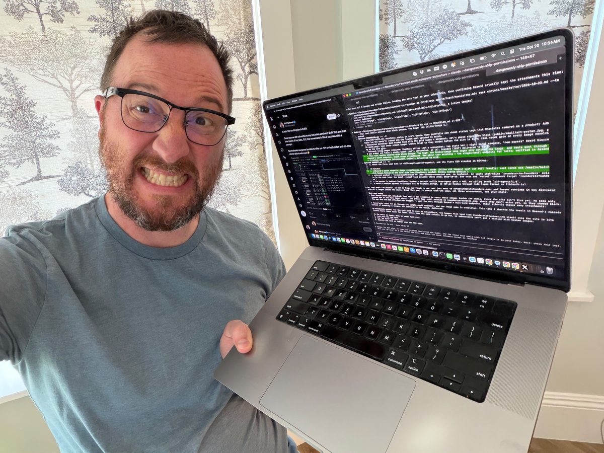 Art grimacing at the camera, holding a laptop with a wall of terminal tabs and Twitter open